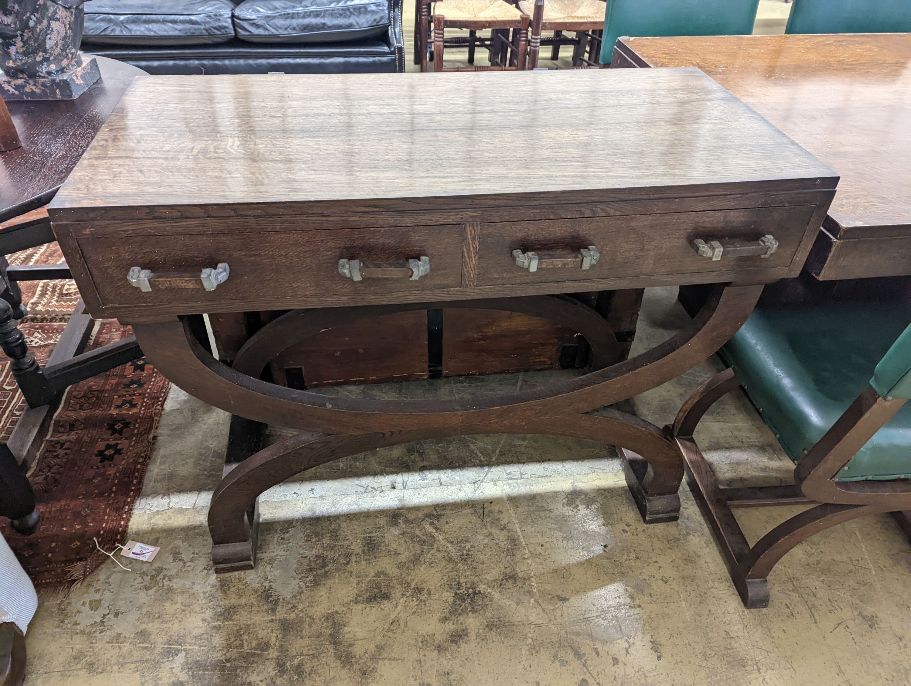 An early 20th century oak dining suite comprising rectangular table, length 216cm, width 106cm, height 74cm together with eight 'X' frame chairs and serving table